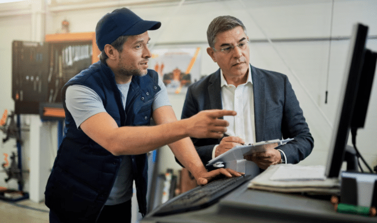 Imagem do artigo Ideias para eficência operacional para empresas | Apresenta dois homens conversando em um ambiente corporativo da indústria